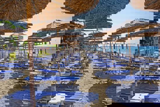 Beach Bar με ξαπλώστρες μπροστά από τη Villa Fofo